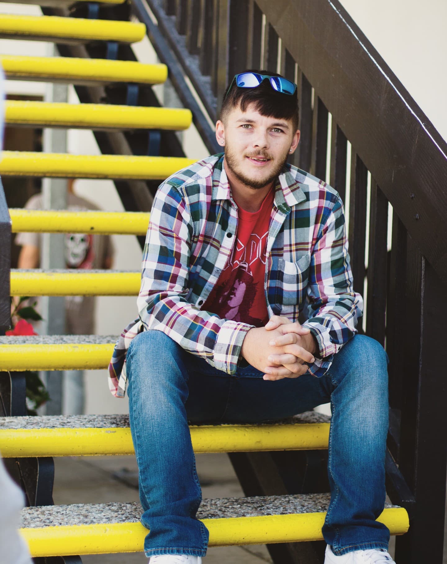 Client sitting on a sunlit staircase.