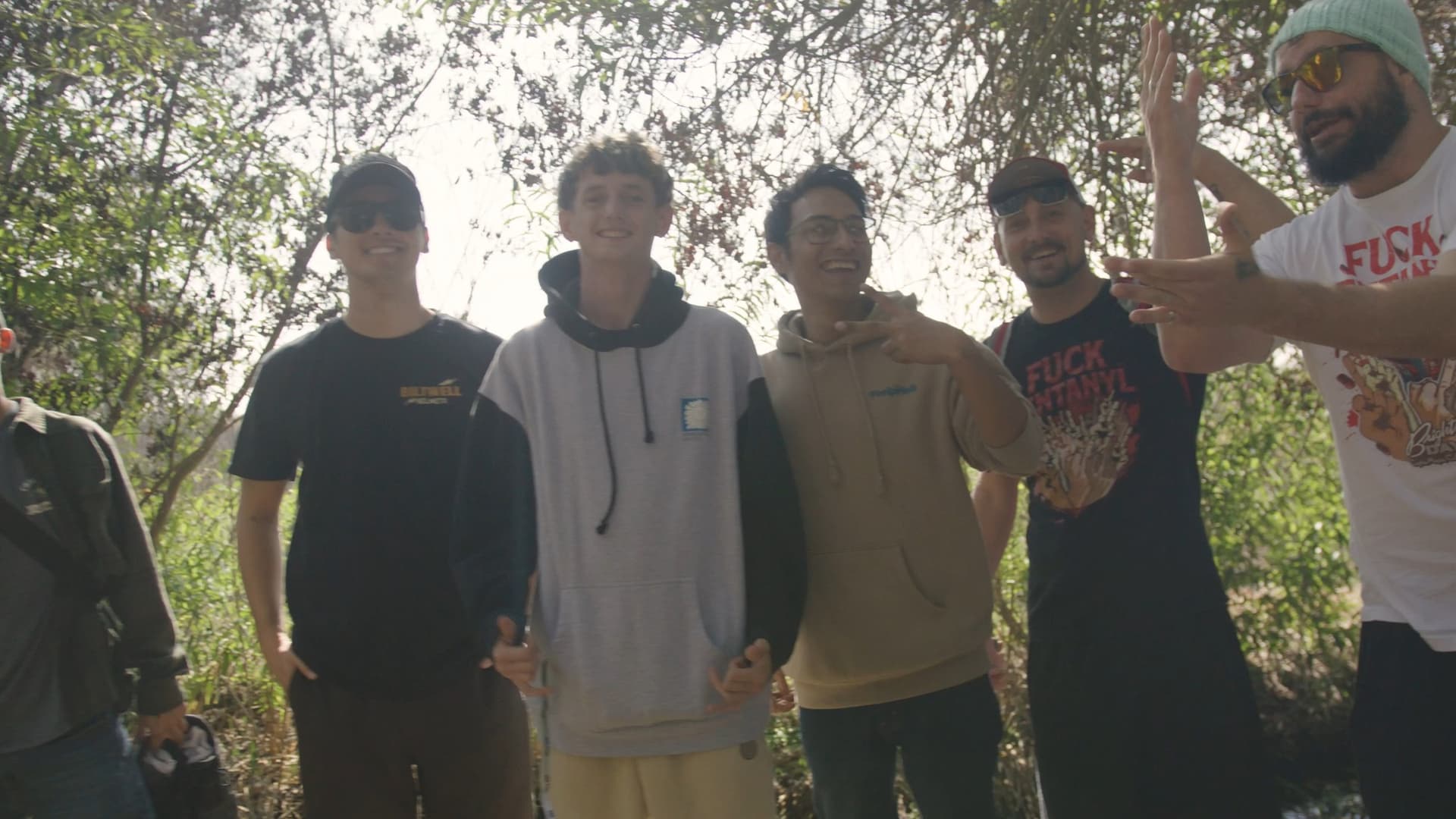 Clients smiling together while standing in a lush natural setting.